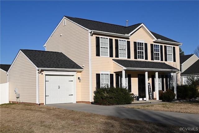 colonial-style house featuring a garage, covered porch, and a front yard