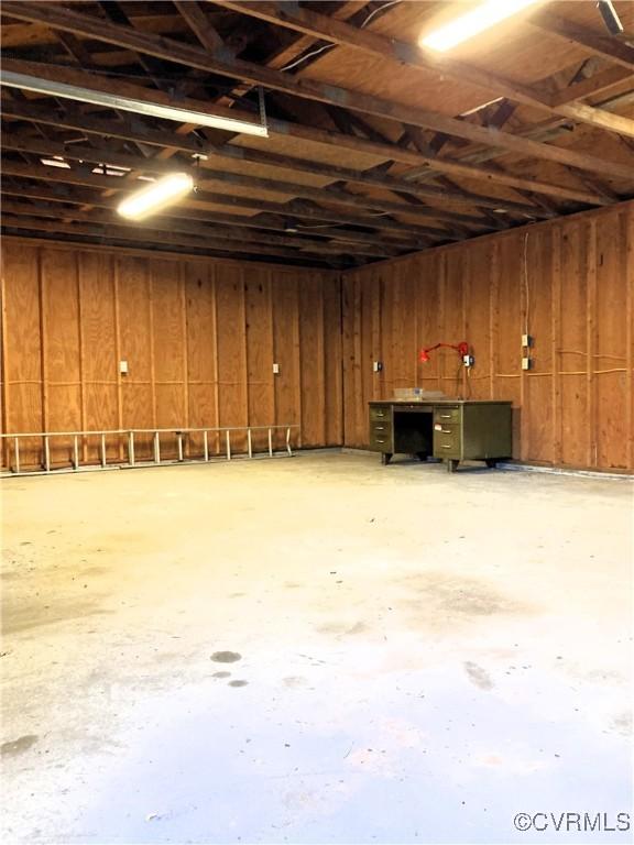 basement featuring wooden walls