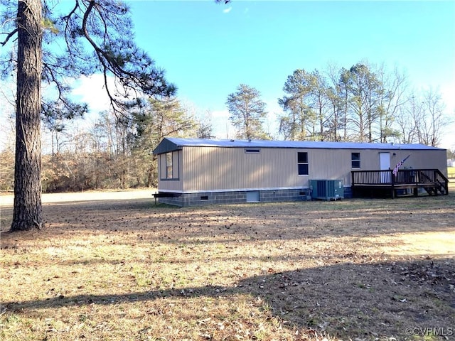 back of property featuring cooling unit, a yard, and a deck