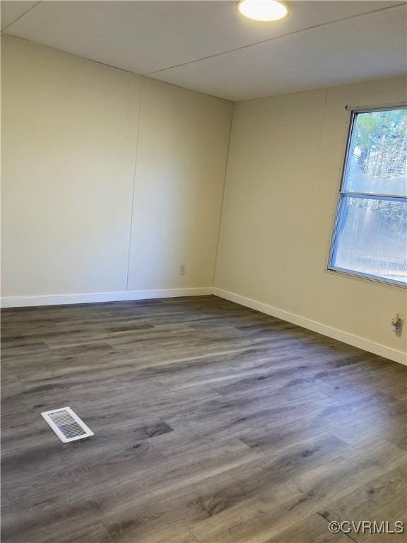 unfurnished room with dark hardwood / wood-style flooring