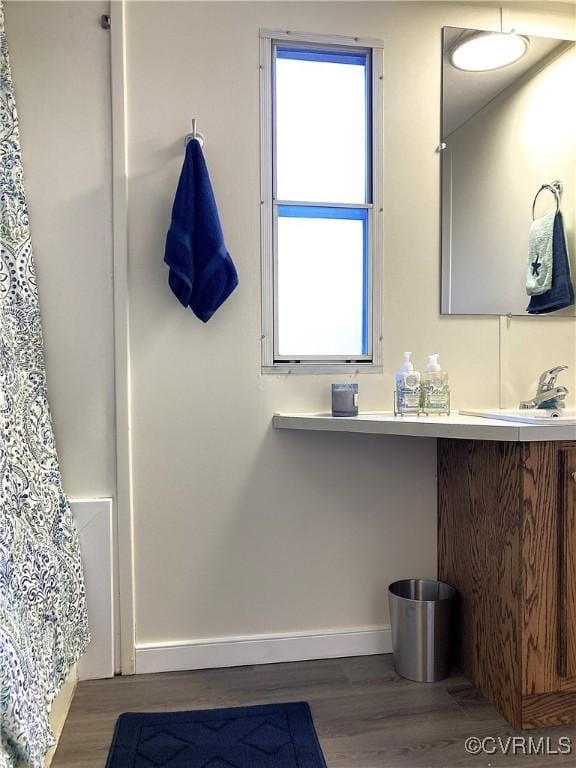 bathroom featuring vanity, hardwood / wood-style flooring, and curtained shower