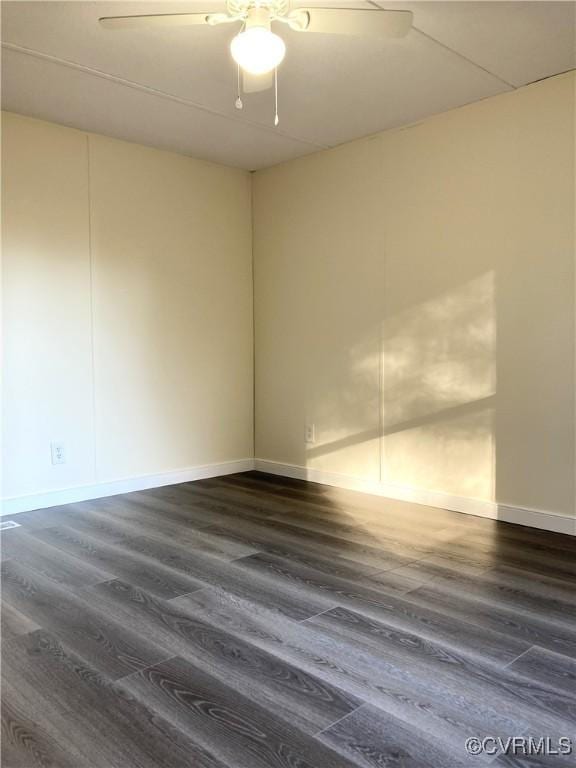 spare room featuring dark wood-type flooring and ceiling fan