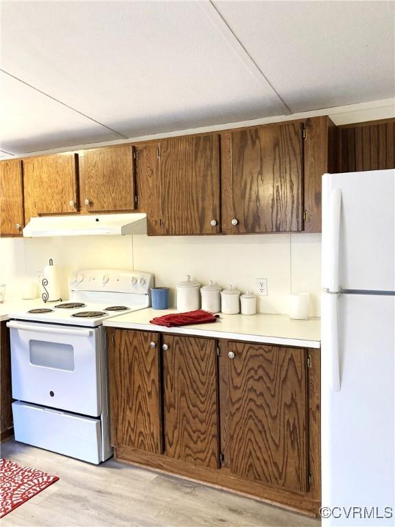 kitchen with light wood-type flooring and white appliances