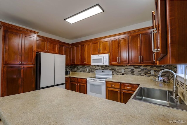 kitchen featuring tasteful backsplash, sink, white appliances, and kitchen peninsula