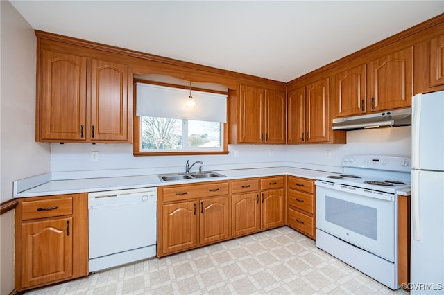 kitchen featuring sink, white appliances, and decorative light fixtures