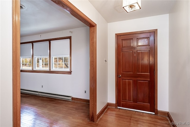 entryway with a baseboard heating unit and wood-type flooring