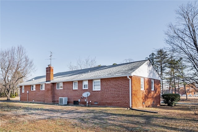 view of property exterior with central AC unit and a yard