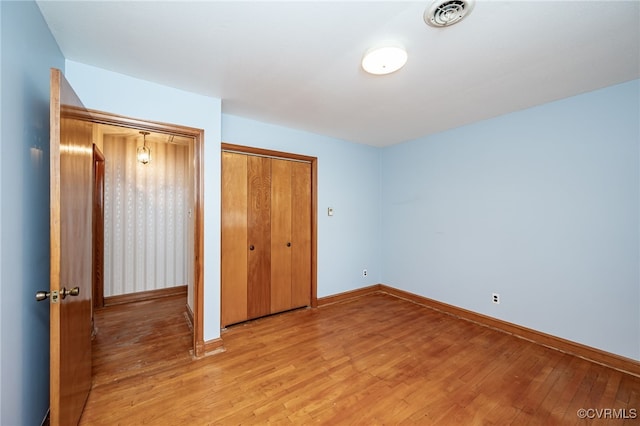 unfurnished bedroom featuring a closet and light hardwood / wood-style flooring