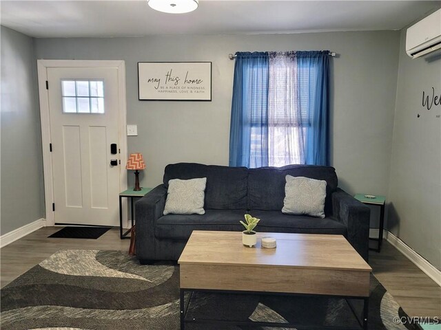 living room with plenty of natural light, dark hardwood / wood-style floors, and a wall unit AC