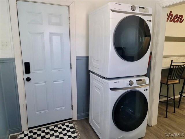 laundry room with stacked washer and dryer and dark hardwood / wood-style floors