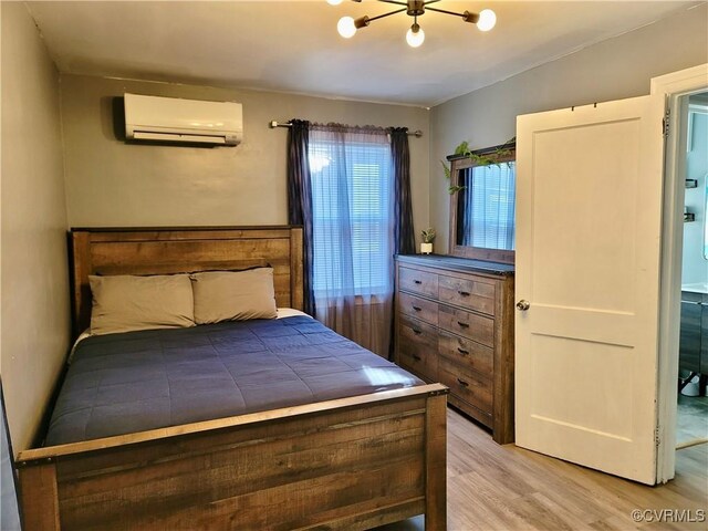 bedroom featuring a wall mounted air conditioner and light wood-type flooring