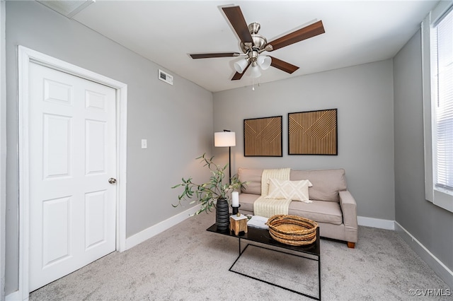 living area with ceiling fan and light carpet