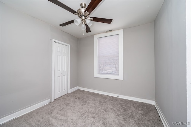 carpeted spare room featuring ceiling fan