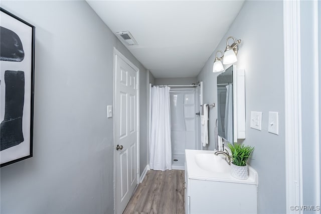 bathroom featuring wood-type flooring, a shower with shower curtain, and vanity