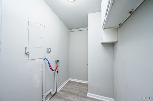 laundry room with washer hookup, electric panel, and light wood-type flooring