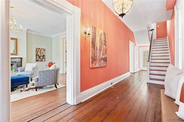 hall featuring an inviting chandelier, crown molding, and hardwood / wood-style floors