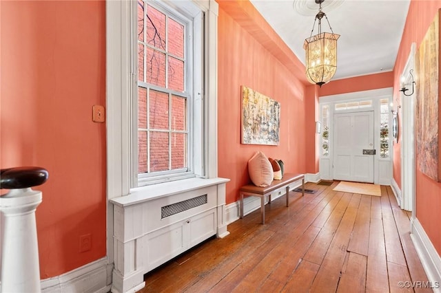 foyer entrance featuring hardwood / wood-style flooring and a chandelier