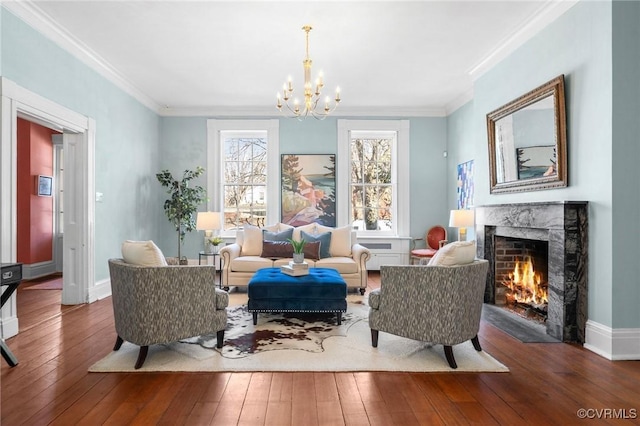 sitting room featuring ornamental molding, wood-type flooring, an inviting chandelier, and a high end fireplace