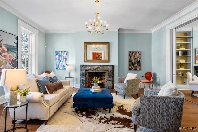 living room featuring a premium fireplace, ornamental molding, hardwood / wood-style floors, and an inviting chandelier