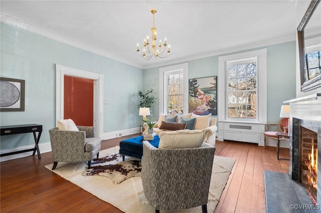 sitting room featuring dark hardwood / wood-style flooring, ornamental molding, a premium fireplace, and a chandelier