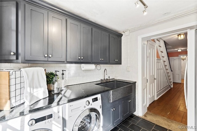 washroom featuring sink, crown molding, washing machine and dryer, and cabinets