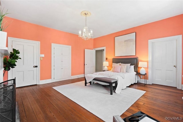 bedroom with a notable chandelier and dark hardwood / wood-style flooring