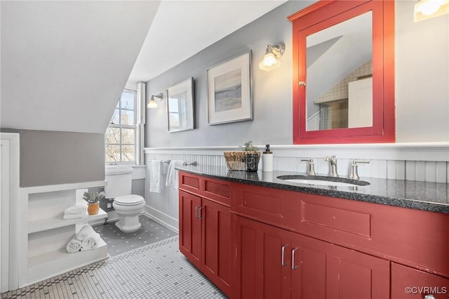 bathroom featuring tile patterned flooring, vaulted ceiling, vanity, and toilet