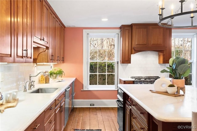 kitchen featuring hanging light fixtures, sink, a wealth of natural light, and light hardwood / wood-style floors