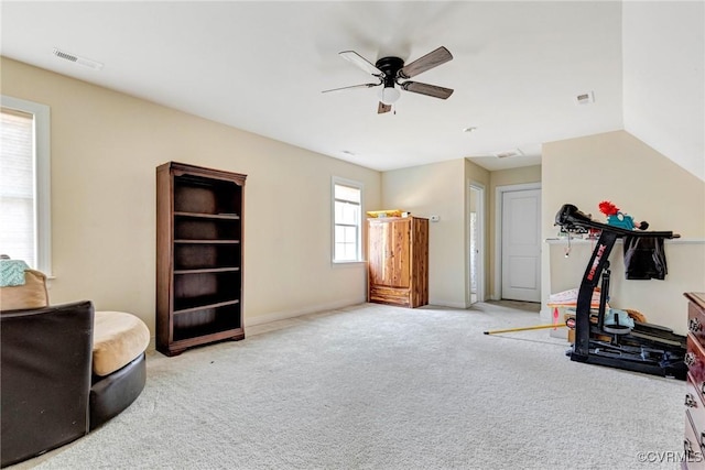 workout room with ceiling fan and light colored carpet