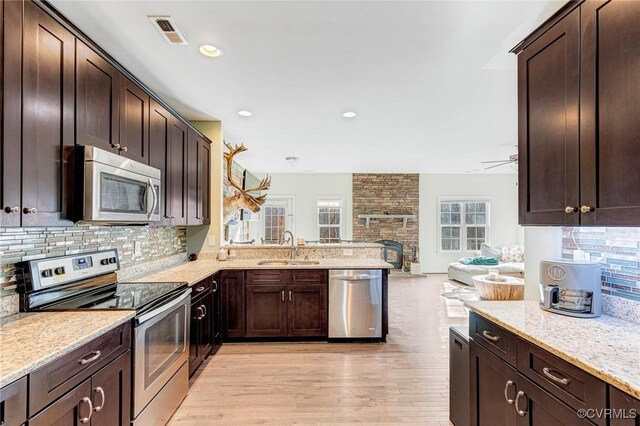 kitchen with stainless steel appliances, kitchen peninsula, sink, and decorative backsplash