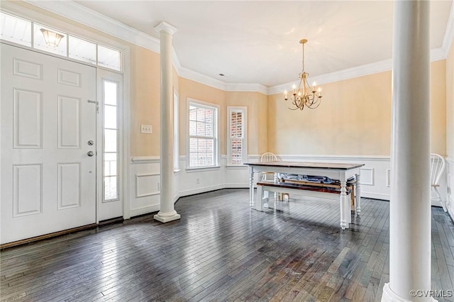 foyer entrance featuring decorative columns, crown molding, and dark hardwood / wood-style floors