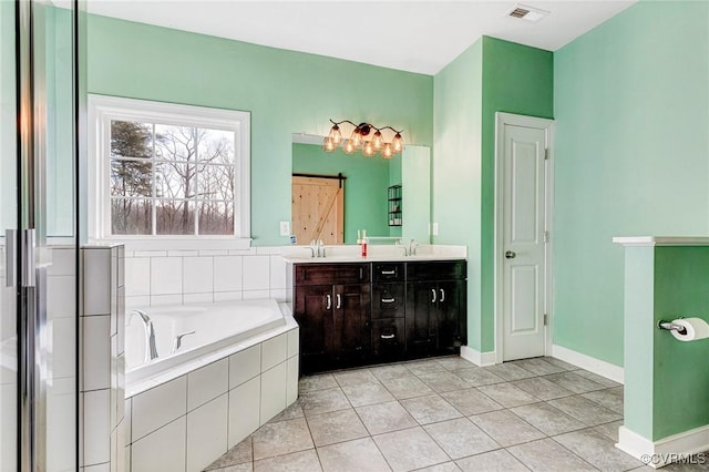 bathroom featuring a relaxing tiled tub, tile patterned floors, and vanity