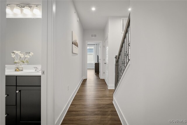 hall with sink and dark wood-type flooring