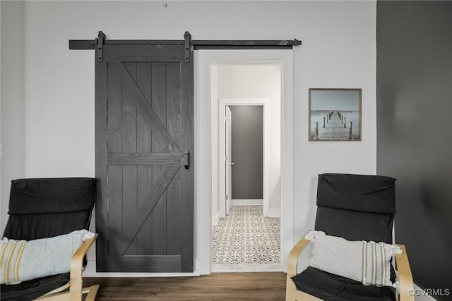 living area with a barn door and dark hardwood / wood-style floors