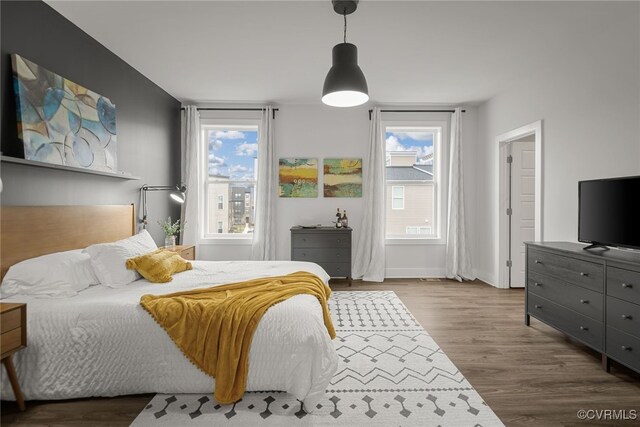 bedroom with multiple windows and hardwood / wood-style floors