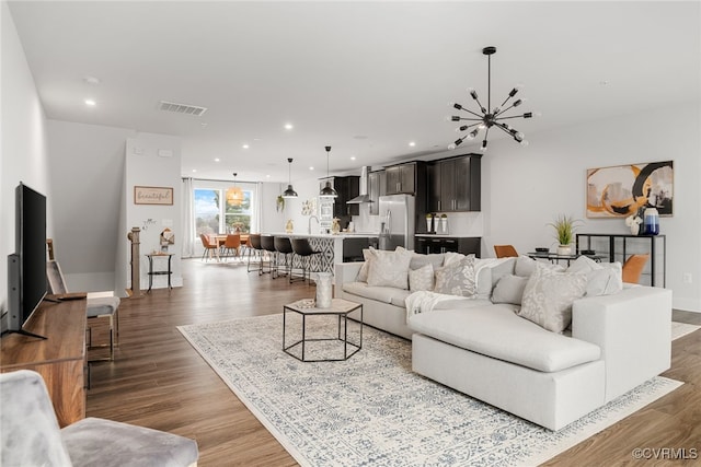 living room with wood-type flooring and a chandelier