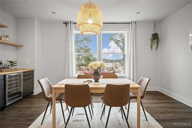 dining space featuring bar area, wine cooler, and dark hardwood / wood-style flooring