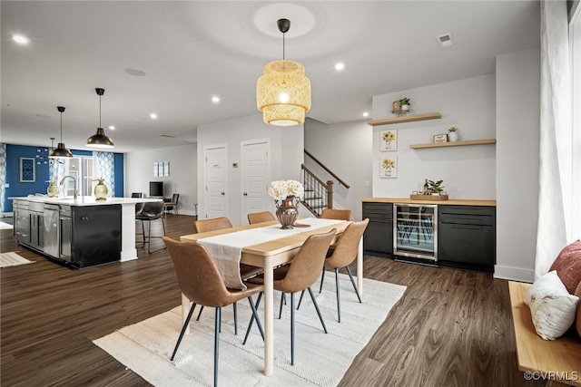 dining room with dark wood-type flooring, wet bar, and wine cooler