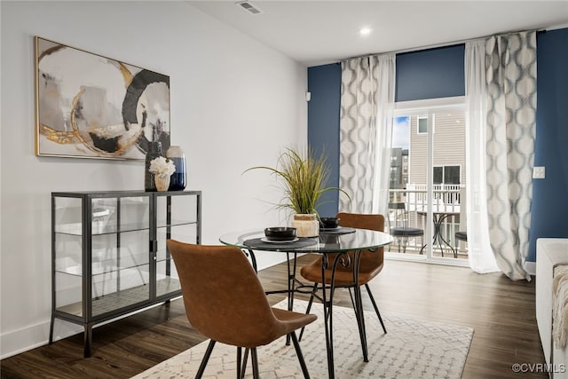 dining space with dark wood-type flooring and expansive windows