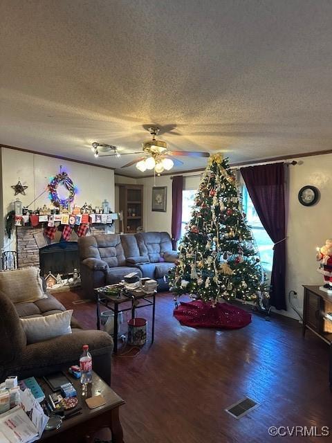 living room featuring ceiling fan, dark wood-type flooring, and a textured ceiling