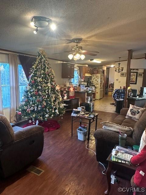 living room with ceiling fan, hardwood / wood-style floors, and a textured ceiling