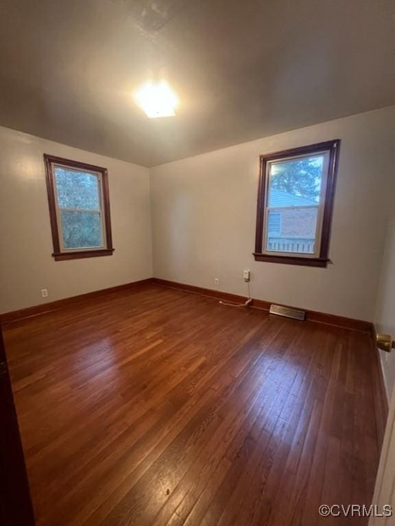 spare room with dark wood-type flooring