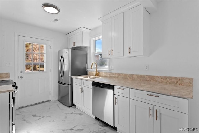 kitchen with sink, white cabinets, and appliances with stainless steel finishes