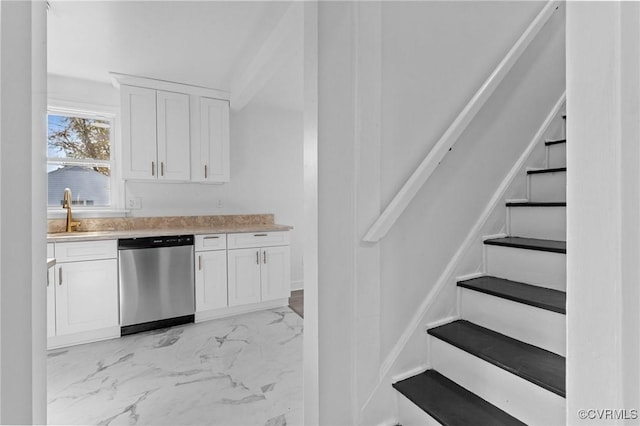 kitchen featuring white cabinetry, stainless steel dishwasher, and sink