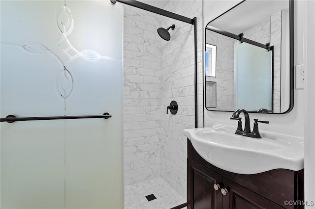 bathroom featuring a tile shower and vanity