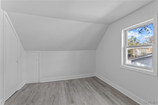 bonus room with vaulted ceiling and light hardwood / wood-style flooring