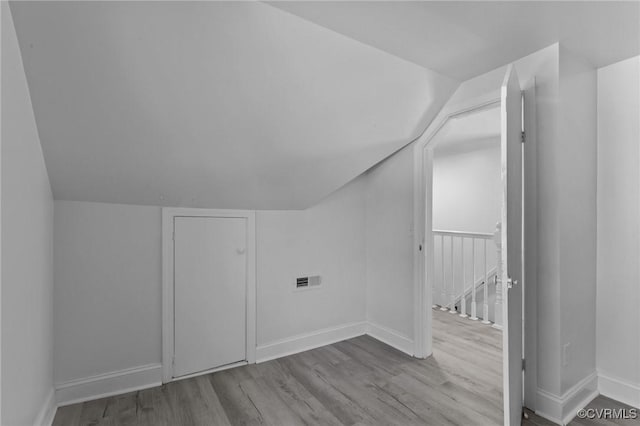 bonus room with vaulted ceiling and light hardwood / wood-style floors