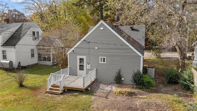 back of house with central AC unit and a lawn