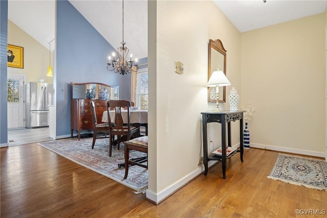 interior space with hardwood / wood-style floors, high vaulted ceiling, and a chandelier