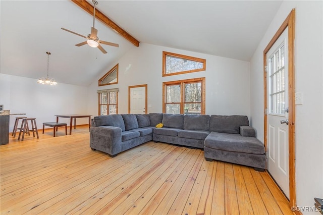 living room with ceiling fan with notable chandelier, high vaulted ceiling, beam ceiling, and light hardwood / wood-style floors